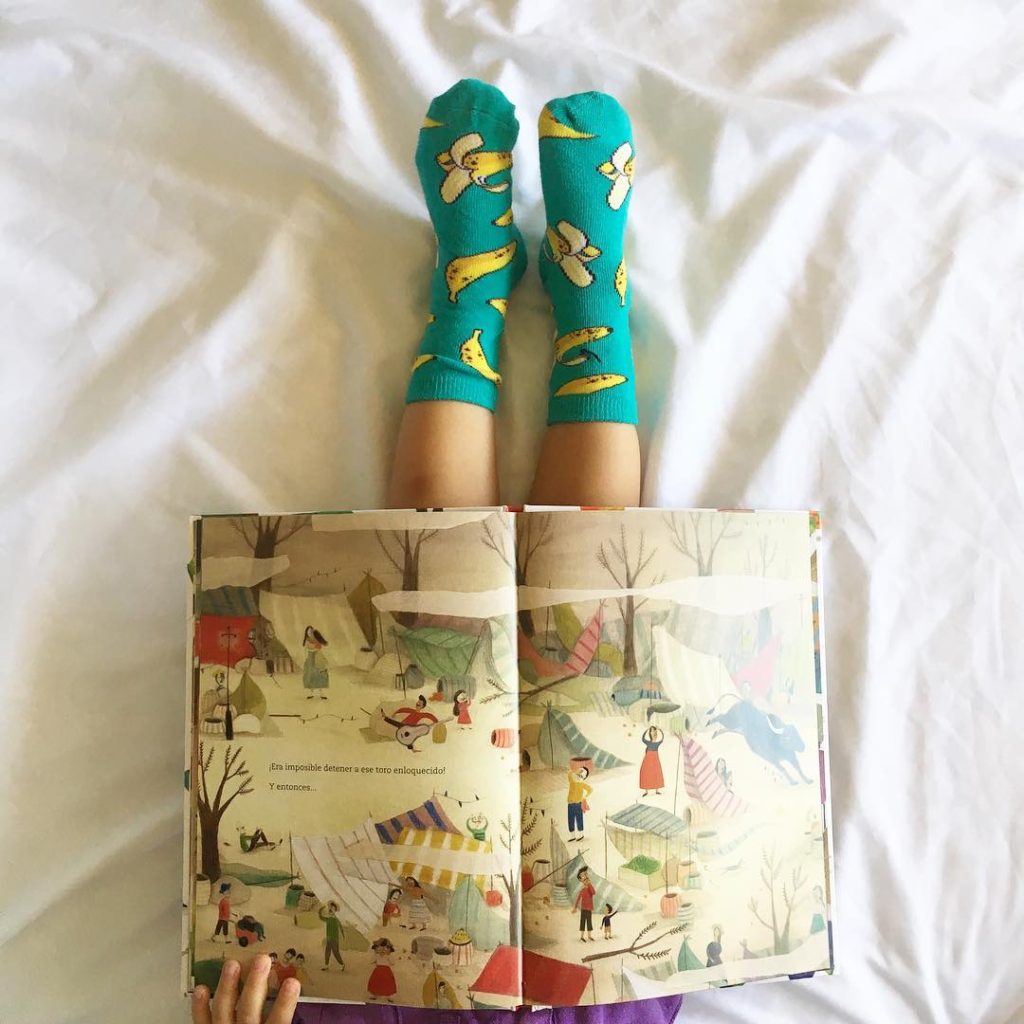 Child learning vocabulary by reading, in socks