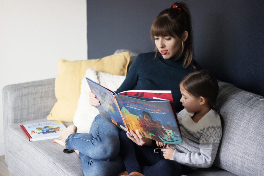 madre e hija leyendo un libro navideño