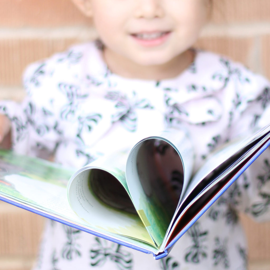 Girl holding book with heart