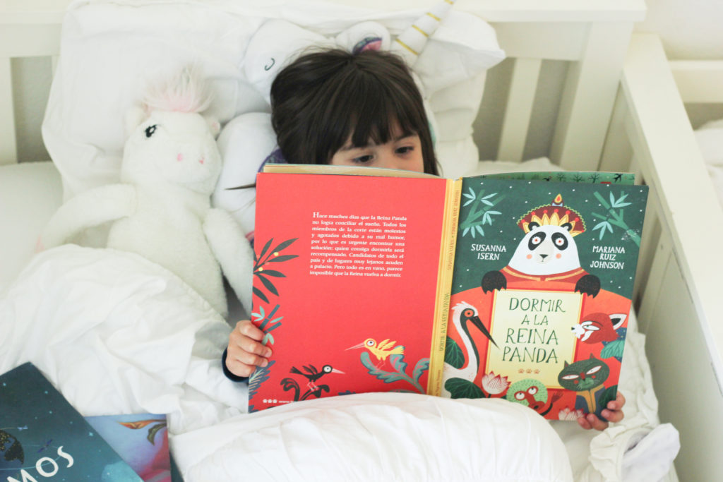 Little girl reading in bed