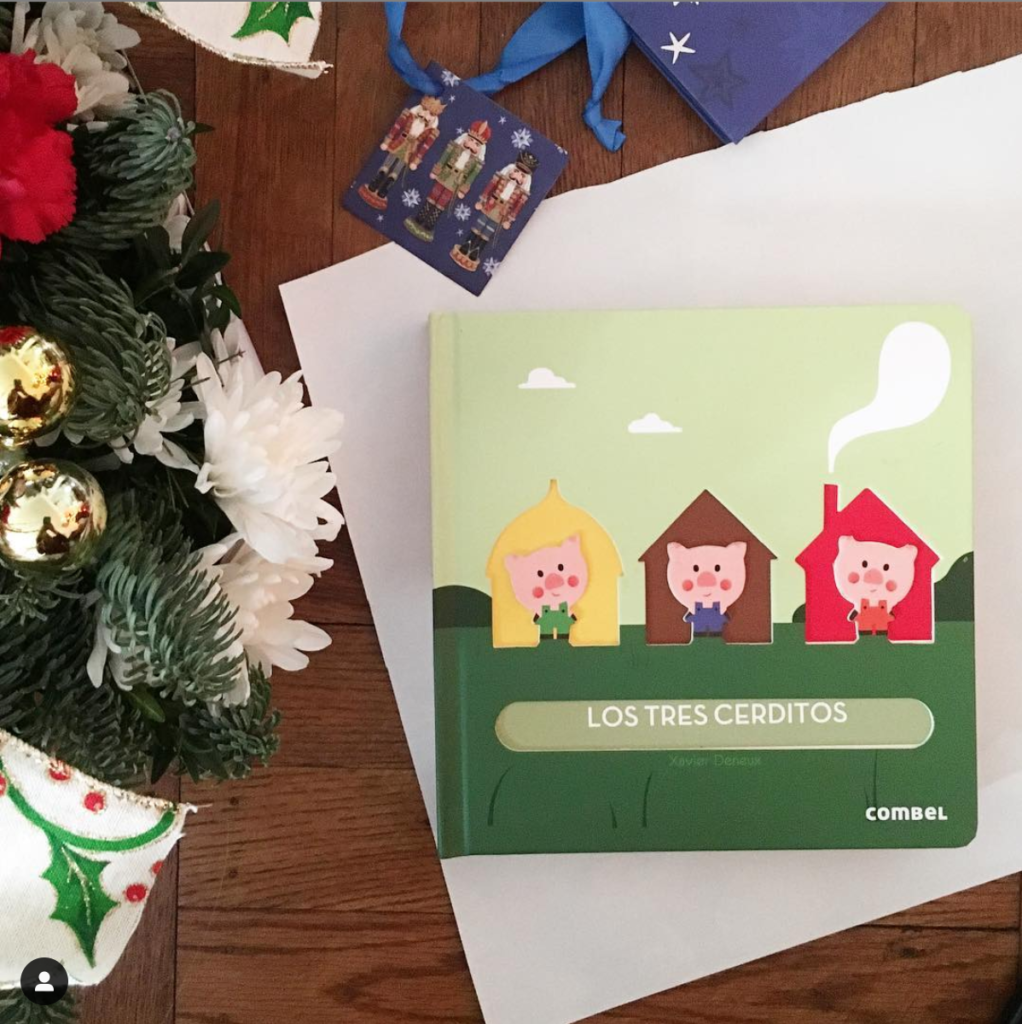 Children's book being wrapped in Christmas wrapping paper. 